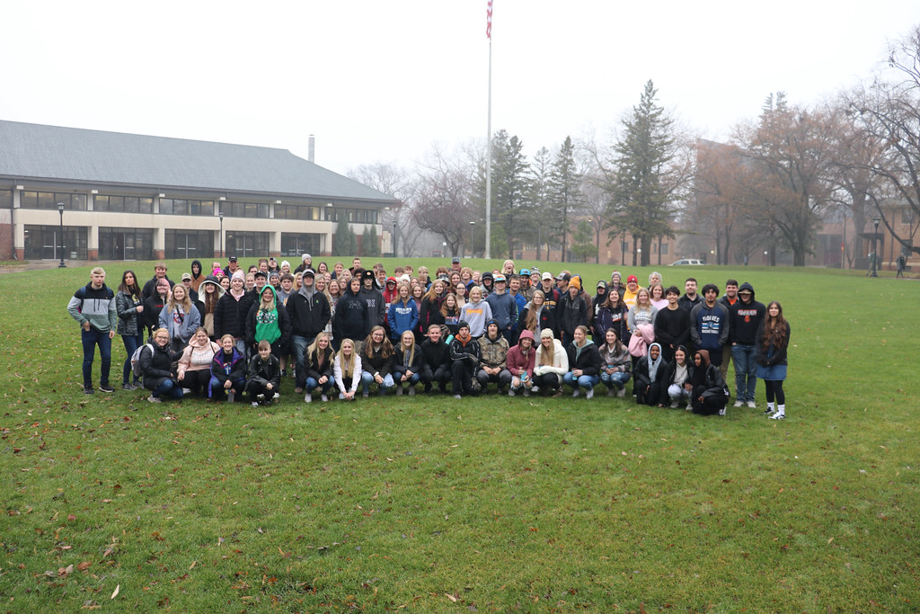 A group of 100 high school students gathered on the UMN Morris campus mall with the student center building behind them.  