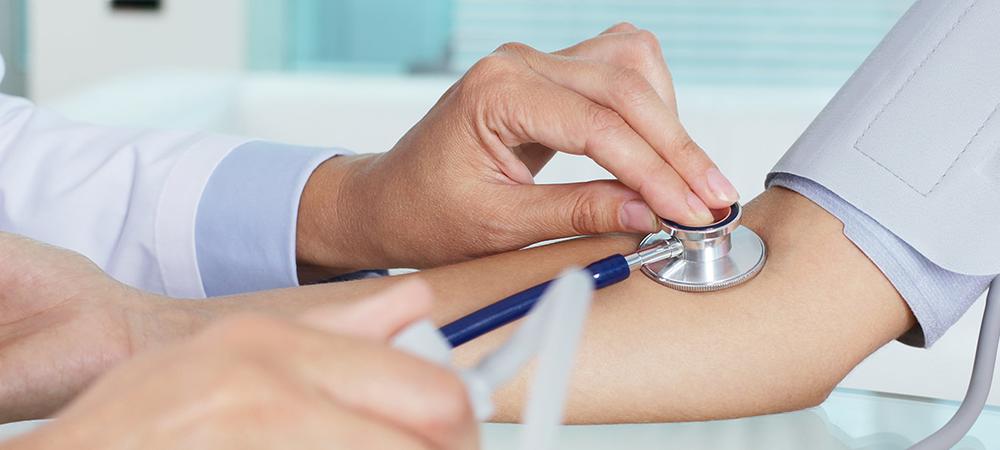 medical professional checks patient's blood pressure