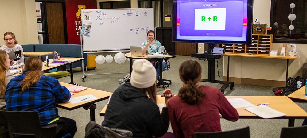 A tutoring group plays a Jeopardy-style game to review for an exam in the Student Success Center.