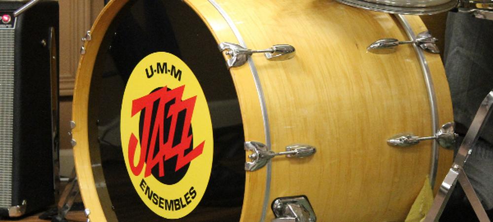 A trap drum set with the UMM Jazz Ensembles logo 