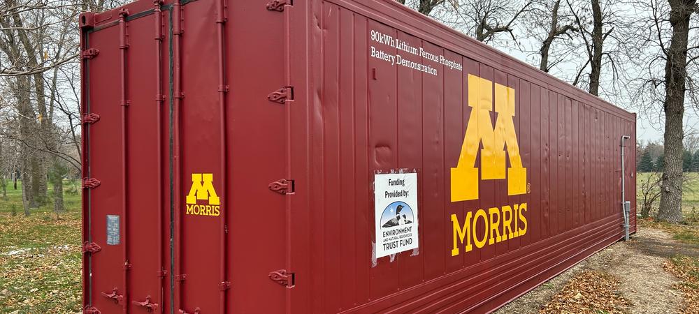 A semi trailer storage container that is maroon with gold lettering that says Morris