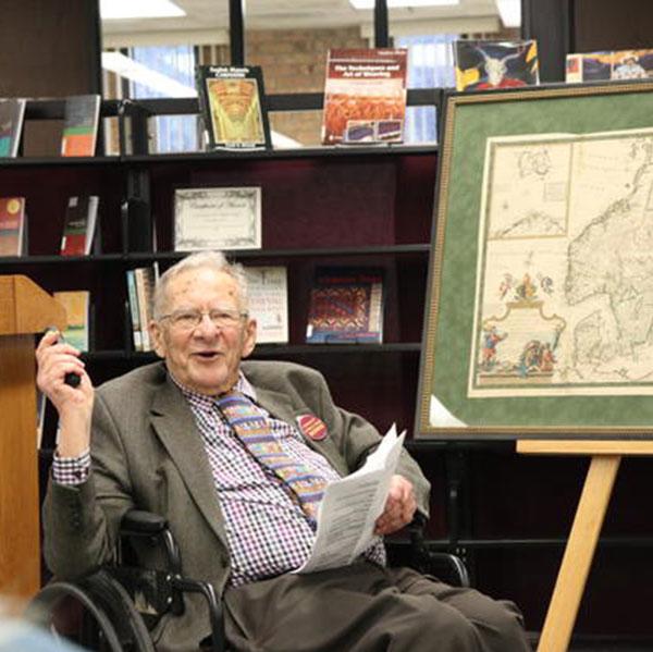 David C. Johnson, chancellor emeritus, discussing one of the maps he donated to campus.
