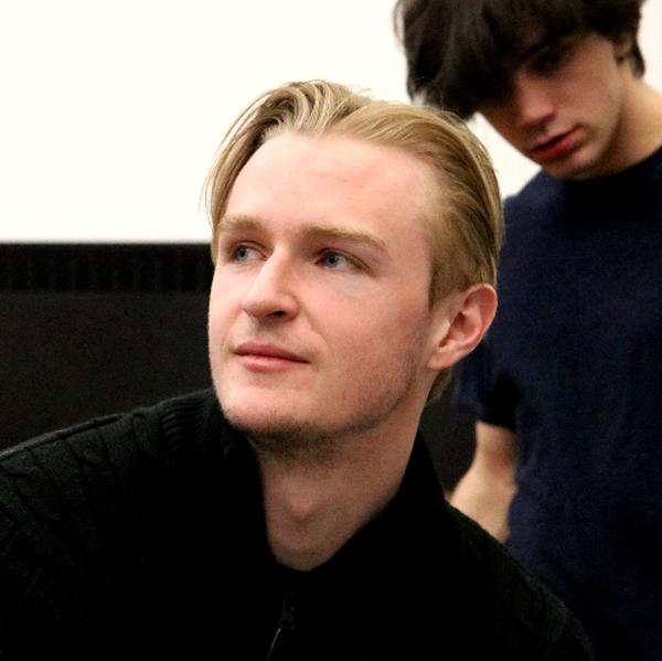 A photo of Brendan Conroy, a male college student with blonde hair.  He is wearing a black shirt and looking off the left. 