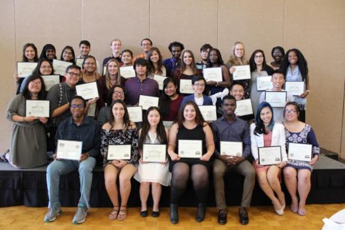 A group of thirty three students holding received awards