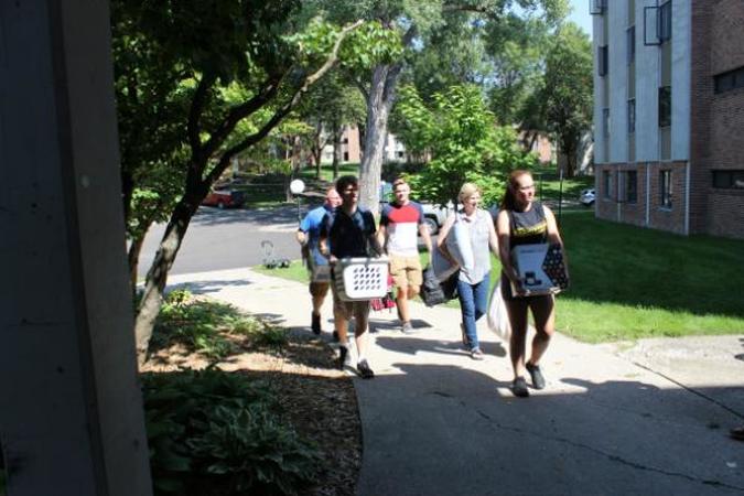 A group of students moving into a residence hall
