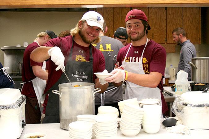Two Cougar football players serve soup at a Morris Community Meal.