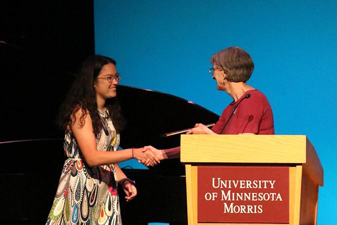 student receives an award on stage from the chancellor
