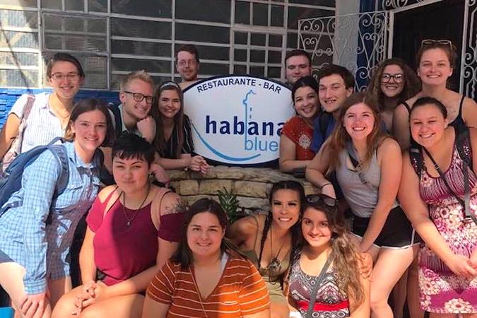 group of UMN Morris students posing in front of a restaurant in Cuba