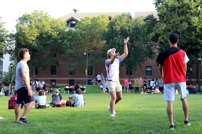 Students toss around a volleyball on the campus mall