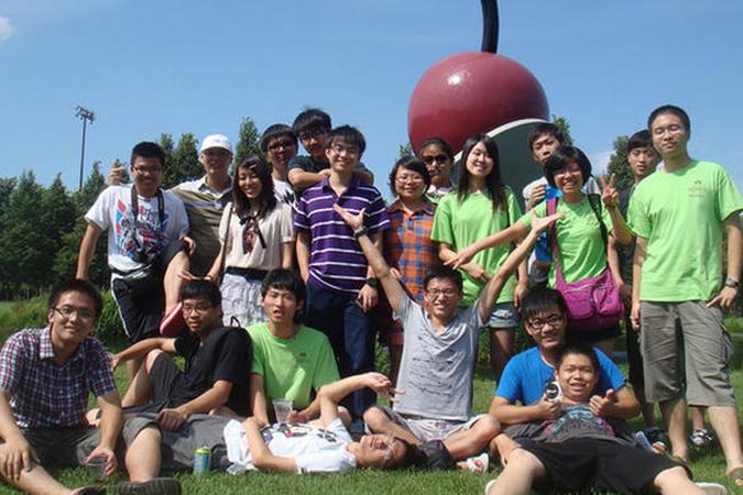 A group of international students standing in front of the Spoonbridge and Cherry art in Minneapolis MN
