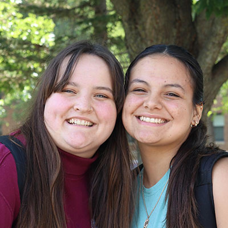 Two students smile into lens