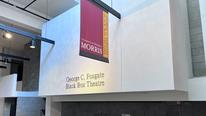 A wall with the words, George C. Fosgate Black Box Theatre, with a maroon and gold banner hanging in front of it. 
