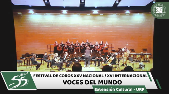 A choral performance at the Festival de Coros XXV Nacional / XVI Internacional Voces del Mundo, hosted by the Extensión Cultural - URP. The choir is standing on stage with a conductor in front, and seated musicians with various instruments are also visible. The stage has a green backdrop with event details and logos of URP displayed.