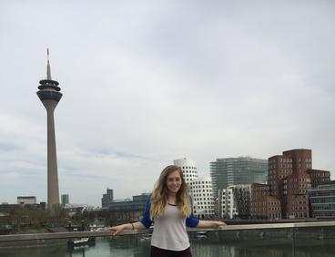 Morris Alum and Fulbright Scholar, Olivia Ilgar standing in front of the Dusseldorf, Germany skyline.