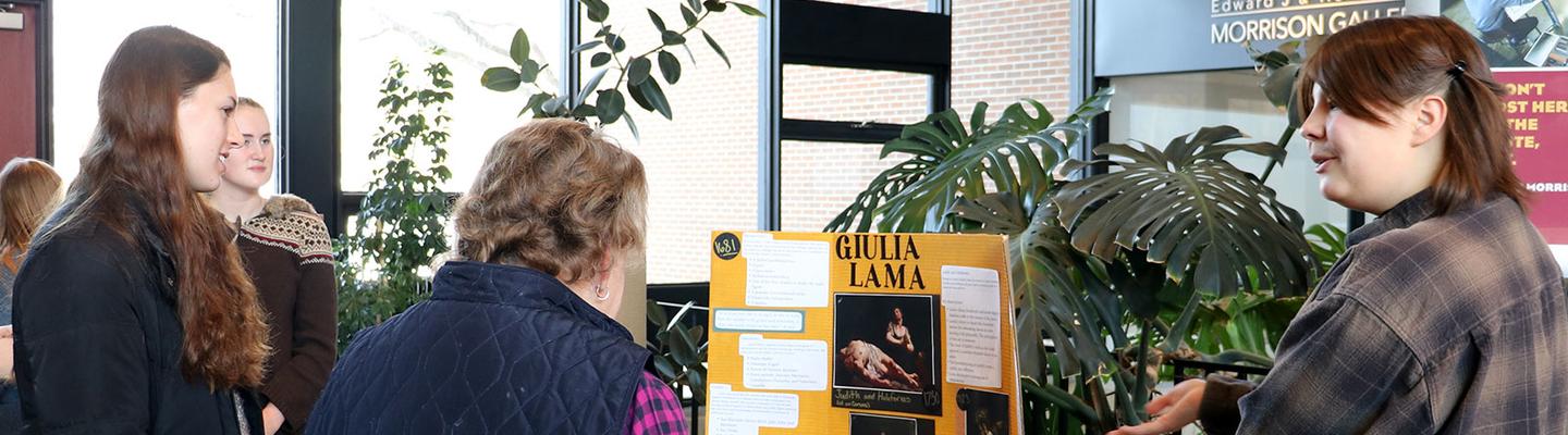 Student in an art history class discuss their research at a poster presentation.
