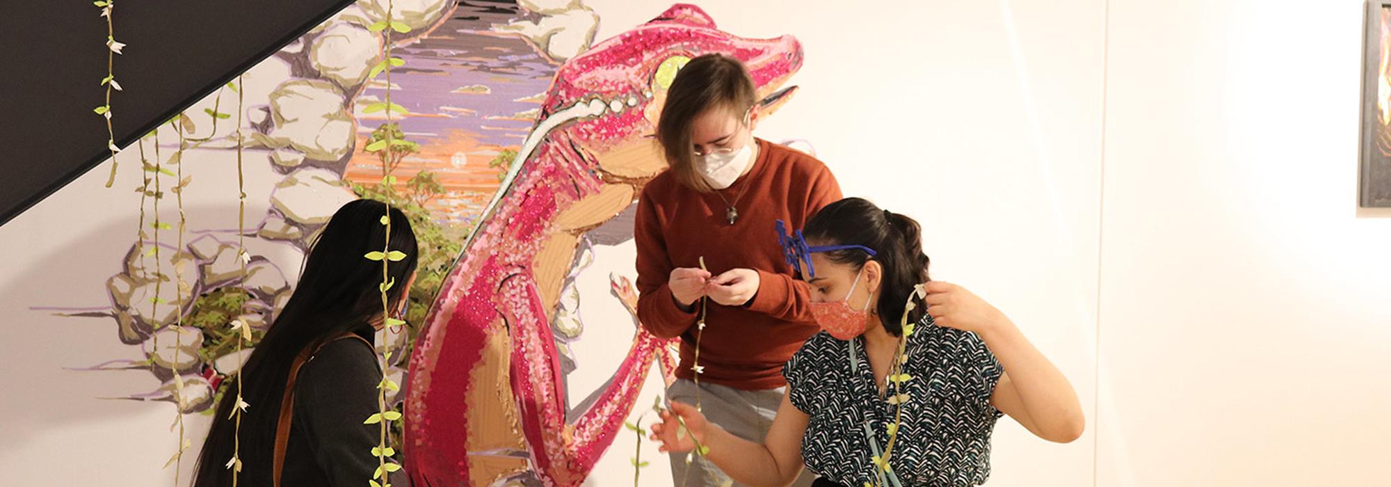 Three students work on an art project in the Morrison Gallery.