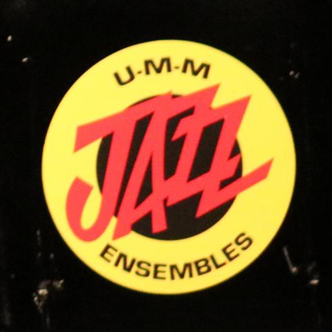 A black background with a yellow donut and the words U-M-M Jazz Ensembles"