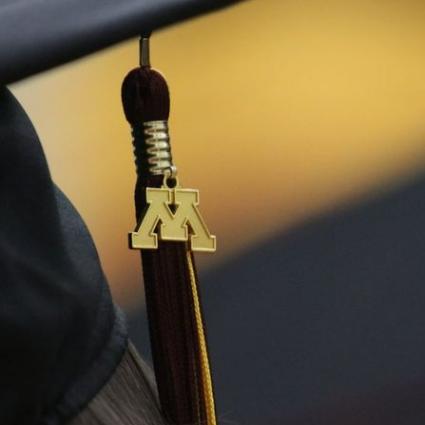 A maroon tassel with a gold M