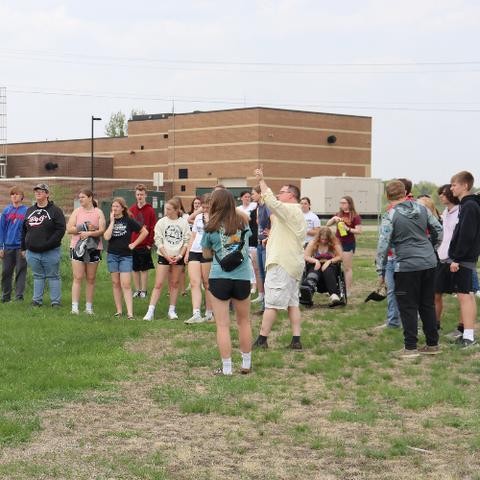 A group of high school students standing outside of a brick building