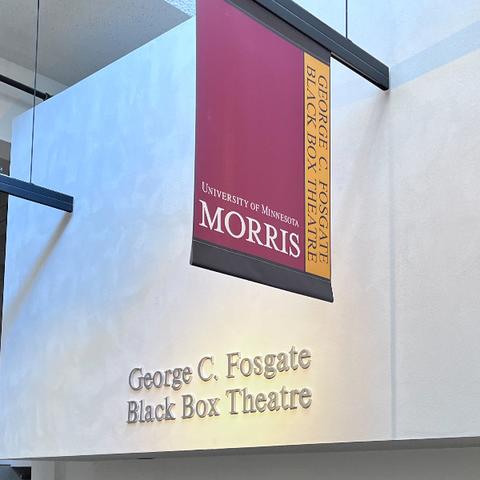 A maroon and gold banner hanging from a wall.  The words, George C. Fosgate Black Box Theatre appear on the wall. 