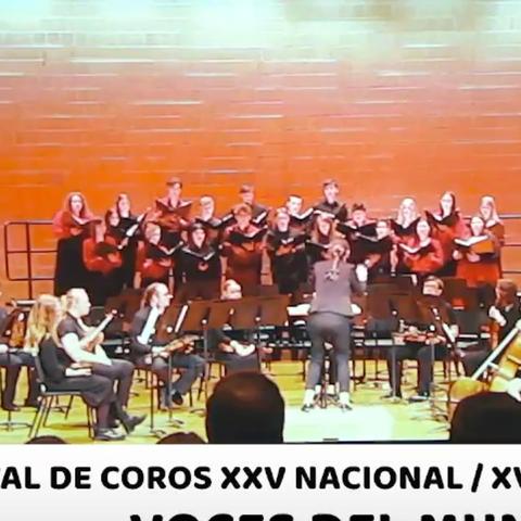 A choir on bleachers on a stage with a small ensemble of musicians.  